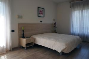 a bedroom with a bed and a dresser with a night stand at Villa Ombretta in Soraga