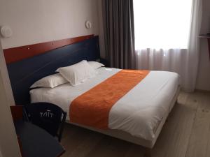 a bedroom with a large bed with an orange blanket at Yatt Hotel in Arcachon