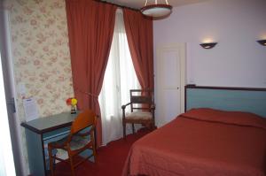 a bedroom with a bed and a desk and a table at A l'abri des vents in Saint-Jean-le-Thomas