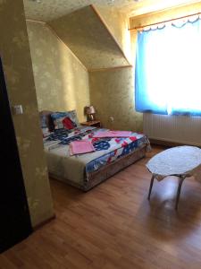 1 dormitorio con cama, mesa y ventana en Holiday en Perekrestʼye