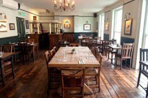 comedor con mesas y sillas de madera en Admiral Hardy en Londres