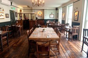 a dining room with wooden tables and chairs at Admiral Hardy in London