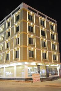 duży żółty budynek z znakiem przed nim w obiekcie E1 Hotel w mieście Al-Chardż