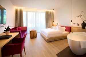 ein Hotelzimmer mit einem Bett und einem Sofa in der Unterkunft Minglers Sportalm - Das Gourmet- und Genießerhotel in Kirchberg in Tirol