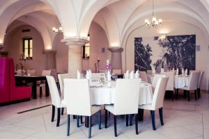 une salle à manger avec des tables et des chaises blanches dans l'établissement Hotel Pałac Krotoszyce Basen&Spa, à Krotoszyce