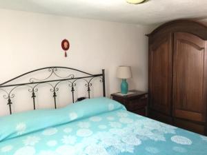 a bedroom with a bed and a wooden cabinet at Giuditta in Putzu Idu