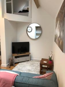 a living room with a blue couch and a mirror at The Little Barn - Self Catering Holiday Accommodation in Hindhead