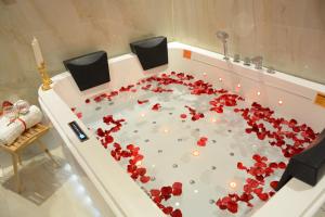 a bath tub filled with red flowers on the floor at E1 Hotel in Al Kharj