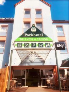 un restaurante con una señal frente a un edificio en Parkhotel Schotten, en Schotten