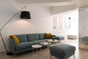 a living room with a blue couch and chairs at Kyriad Montpellier Sud - Lattes in Montpellier