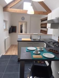 a kitchen with a table with plates on it at Le Buis in Genval