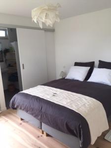 een slaapkamer met een groot bed met zwart-witte kussens bij Le Buis in Genval
