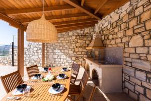 a dining room with a table and a stone wall at Paris Villa, infinite coastal views, By ThinkVilla in Balíon