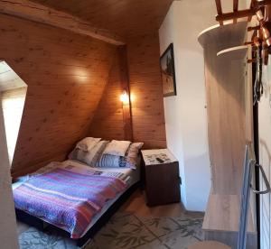łóżko w pokoju z drewnianą ścianą w obiekcie Willa Helena w Cisnej