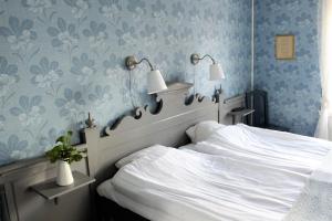 a bedroom with a white bed with blue floral wallpaper at STF Hostel Vilhelmina Kyrkstad in Vilhelmina