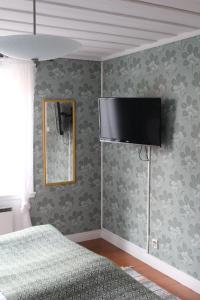 a bedroom with a bed and a television on the wall at STF Hostel Vilhelmina Kyrkstad in Vilhelmina
