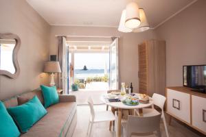 Les Sables Noirs & Spa في فولكانو: غرفة معيشة بها أريكة وطاولة وتلفزيون