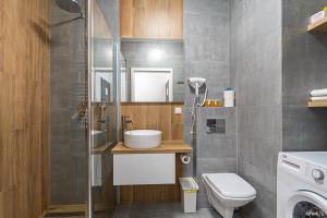 łazienka z toaletą i umywalką w obiekcie Apartament OdraTower (wroc4night) we Wrocławiu +7 zdjęć