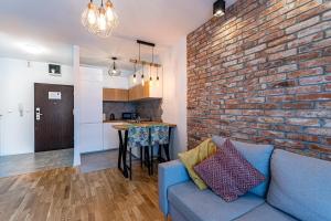 salon z niebieską kanapą i ceglaną ścianą w obiekcie Apartament OdraTower (wroc4night) we Wrocławiu