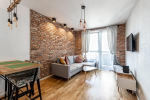 salon z kanapą i ceglaną ścianą w obiekcie Apartament OdraTower (wroc4night) we Wrocławiu