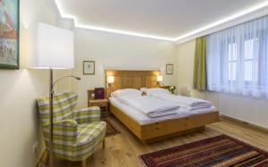 pokój hotelowy z łóżkiem i krzesłem w obiekcie Hotel-Restaurant Kirchenwirt w mieście Weissenkirchen in der Wachau