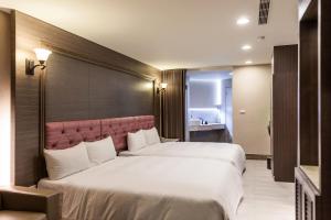 a hotel room with two beds in a room at Maple Hotel Second Branch in Tainan