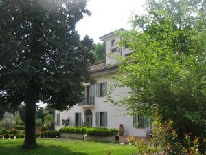 una grande casa bianca con un albero in cortile di Al Melograno - Room & Breakfast a Bologna