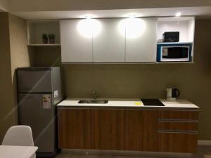 a kitchen with a sink and a refrigerator at Michelle- Departamentos in Necochea