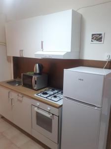 a kitchen with a white refrigerator and a stove at B&B SICILIA in Messina