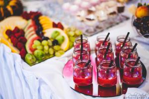 una mesa con un buffet de fruta y vasos de zumo en Lacona, en Stąporków
