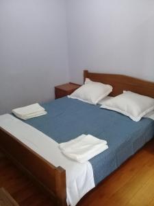 a bedroom with a bed with blue sheets and white pillows at Elmira in Borjomi