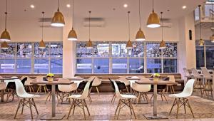 a restaurant with tables and chairs and windows at Dafam Express Jaksa Jakarta in Jakarta