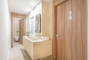 a bathroom with a sink and a wooden door at Casa Lirio in Barcelona +29 photos