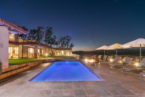 a swimming pool in the backyard of a house at night at Villa Castollini in Brenton-on-Sea