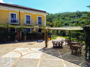 a patio with tables and chairs and a building at That's Amore Cilento Country House in Agnone