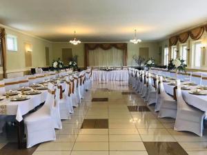 ein großer Festsaal mit weißen Tischen und Stühlen in der Unterkunft HOTEL SAN in Holíč