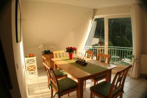 a dining room with a table and chairs and a balcony at Residenz Waldhaus_32 Ostseezauber am Meer in Zempin