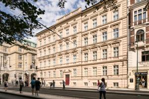 un grand bâtiment avec des personnes debout à l'extérieur dans l'établissement Quentin Prague Hotel, à Prague
