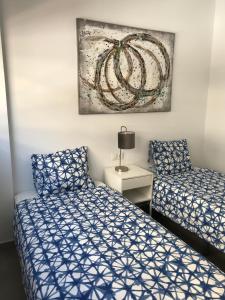 カルプにあるCalpe Beach Boutique Luxury Seaview Suiteのベッドが2つあり、壁に絵が飾られた寝室 +32枚の写真