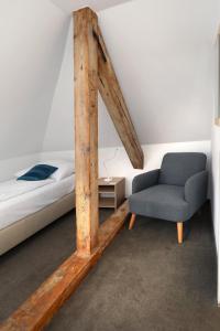 a bedroom with a bed and a chair at Pension U Tří sedláků in České Budějovice