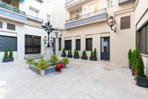une cour d'un bâtiment avec des plantes en pot dans l'établissement UNIQUE HOMES LAS SETAS, PLAZA DE SAN PEDRO 6 Pax, à Séville