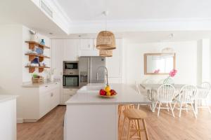 une cuisine blanche avec une table et des chaises dans l'établissement UNIQUE HOMES LAS SETAS, PLAZA DE SAN PEDRO 6 Pax, à Séville