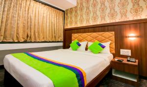 a bedroom with a large bed with a colorful blanket at Treebo Trend Arvind Residency in Mumbai