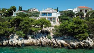 uma casa numa ilha rochosa na água em Villa Stina em Okrug Donji