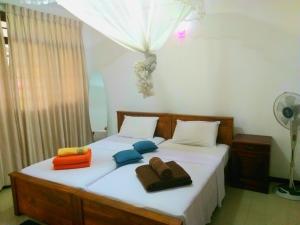 a bedroom with two beds with towels and a fan at 59B Rest Inn Ella in Ella