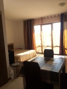 a hotel room with a bed and a desk and a television at Apartment on the sea at St Nikolas Complex-Ira in Chernomorets