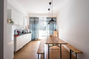 - une cuisine avec une table en bois au milieu d'une pièce dans l'établissement Liberty Hostel Lisbon, à Lisbonne