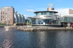 a building on the side of a body of water at Esquire Media City in Manchester