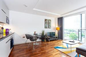 a kitchen and living room with a table and chairs at Esquire Media City in Manchester