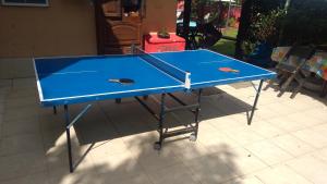 a blue ping pong table with two ping pong rackets at Pousada Bela Casa Geribá in Búzios